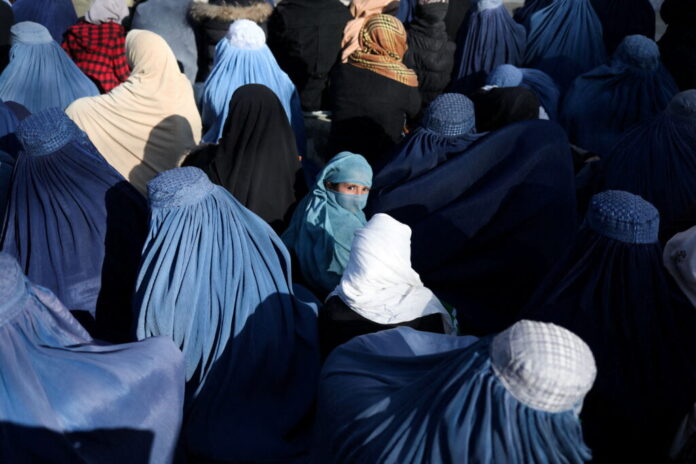People wait to receive bread in Kabul